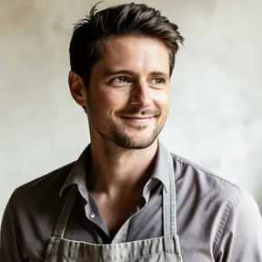 Professional headshot of a French male artisan in his mid 30s, natural daylight, soft studio background, relaxed and confident expression, smart casual attire, realistic photography, high resolution, shallow depth of field
