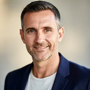 Professional headshot of a French male entrepreneur in his early 40s, natural light, soft neutral background, smart casual outfit, confident and approachable expression, realistic photography, high resolution, shallow depth of field

